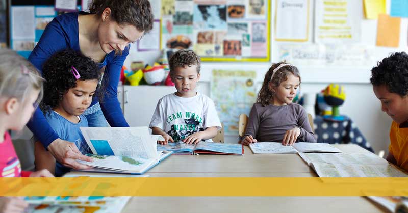 Teacher in classroom working with child students