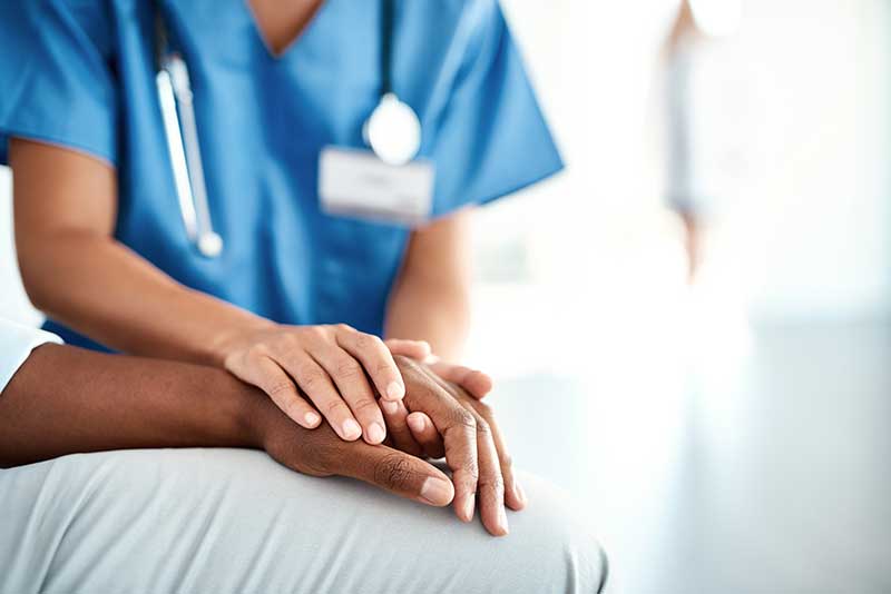 nurse's hand holding patient's hand