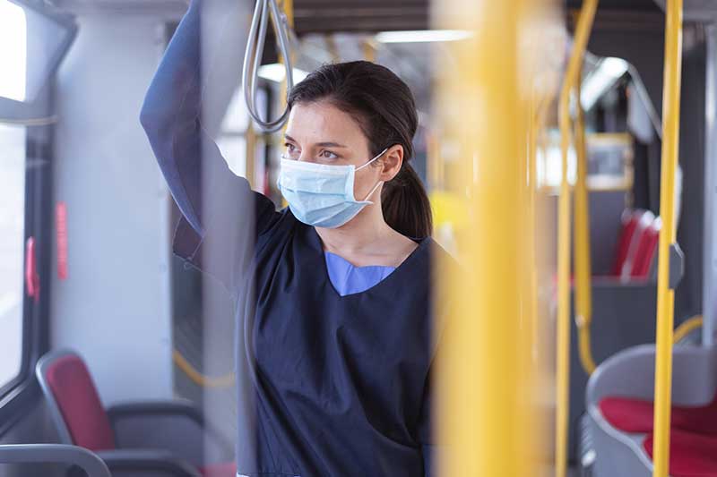 nurse wearing mask and riding on subway